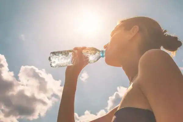 Hydration: The Secret Ingredient for a Toned Stomach and Enhanced Fitness 3 Image of woman drinking water to hydrate Wilmslow after run.