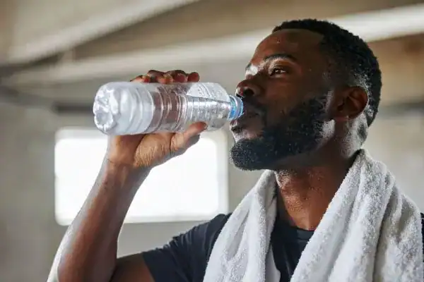 Hydration: The Secret Ingredient for a Toned Stomach and Enhanced Fitness 1 Image of man drinking water to improve hydration Wilmslow after work out.